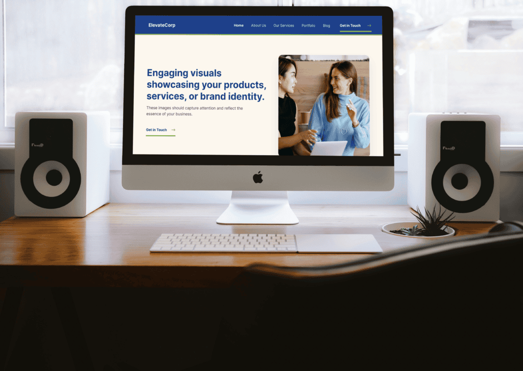 A sleek iMac on a wooden desk displays a website with a text: "Engaging visuals showcasing products, services, or brand identity." Two smiling women converse. Speakers flank the monitor.